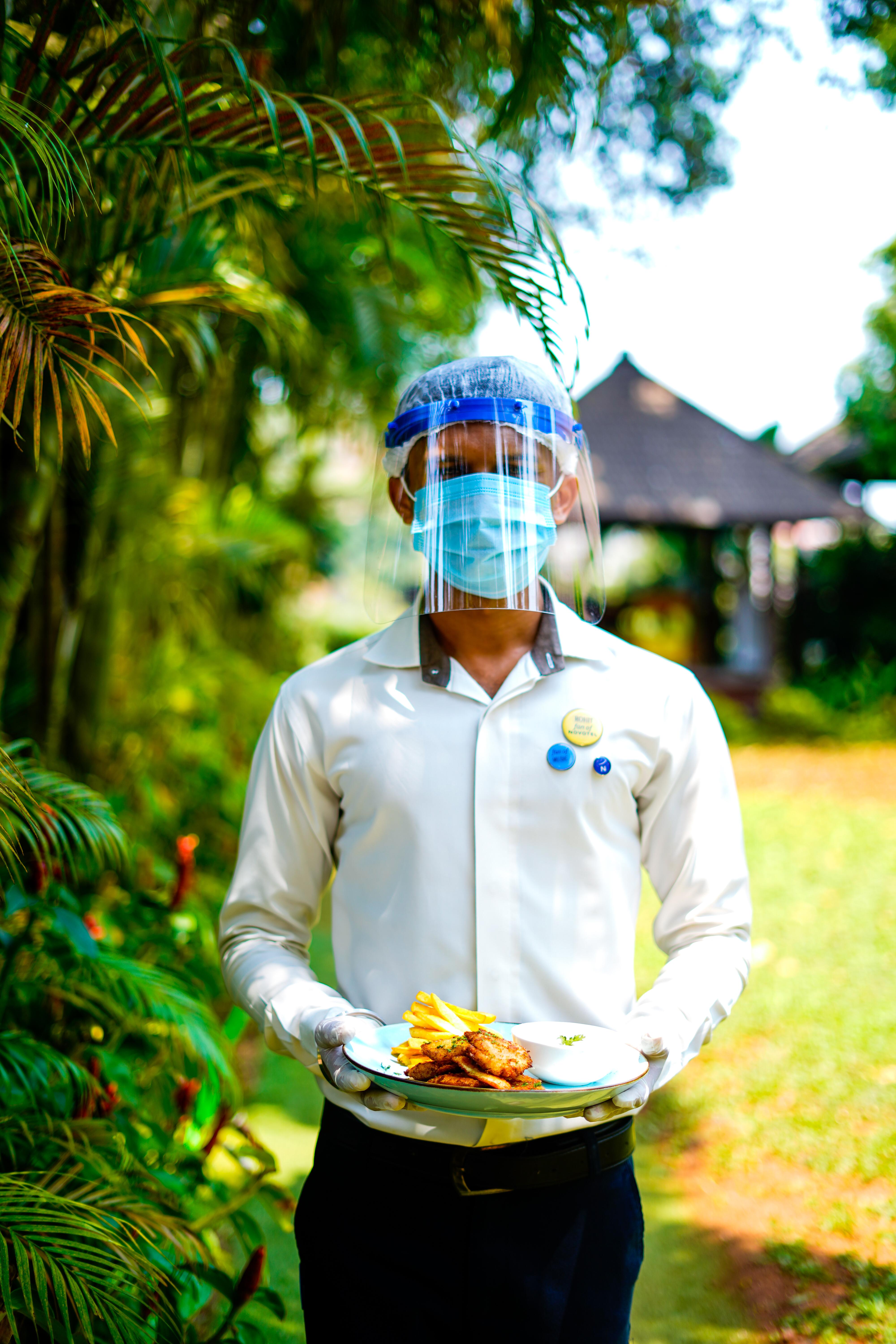 Novotel Goa Resort & Spa Candolim Zewnętrze zdjęcie A hotel employee wearing a face shield and a face mask